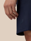 Close-up of navy Flex Shorts hem with embossed CASTORE logo and a resting hand nearby