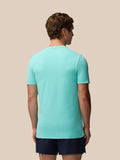 Back view of man wearing light aqua Zone Training T-Shirt with ribbed panels and navy shorts.