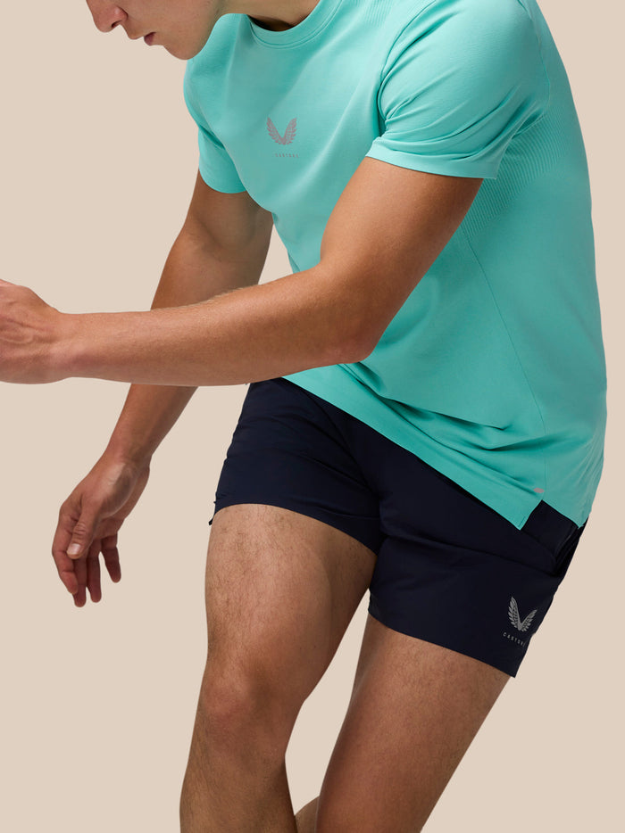 Close-up of a model in a light aqua Zone Training T-Shirt showing relaxed fit and crew neckline with navy shorts