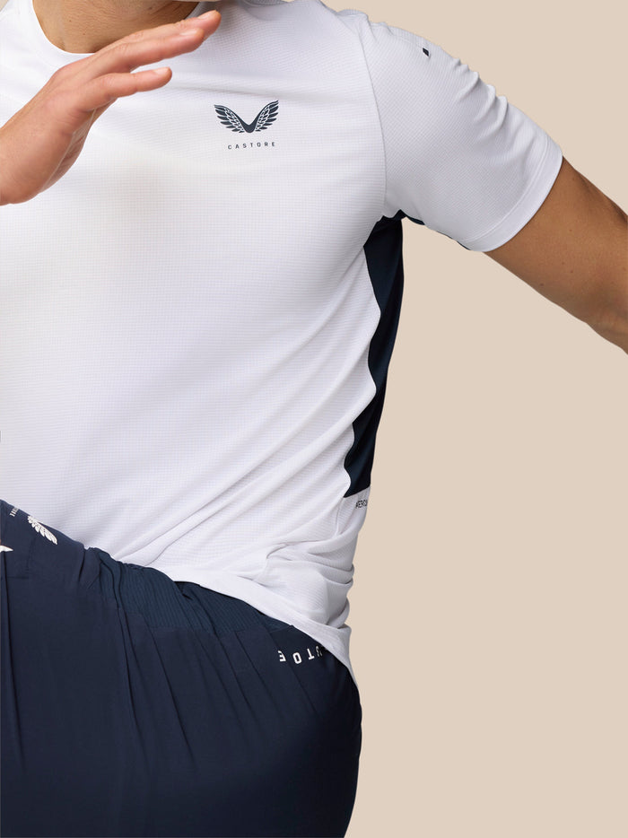 Torso of a person wearing white Apex Training T-Shirt with navy side panels and Castore logo on the chest