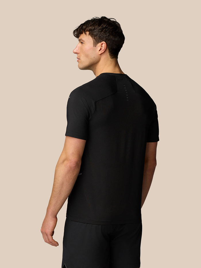 Back view of a man in black Apex Training T Shirt with reflective branding on the upper back.