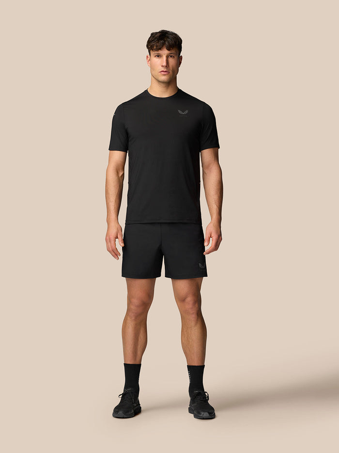 Male model wearing black Apex Training T-Shirt with matching shorts, showcased as athletic gear.