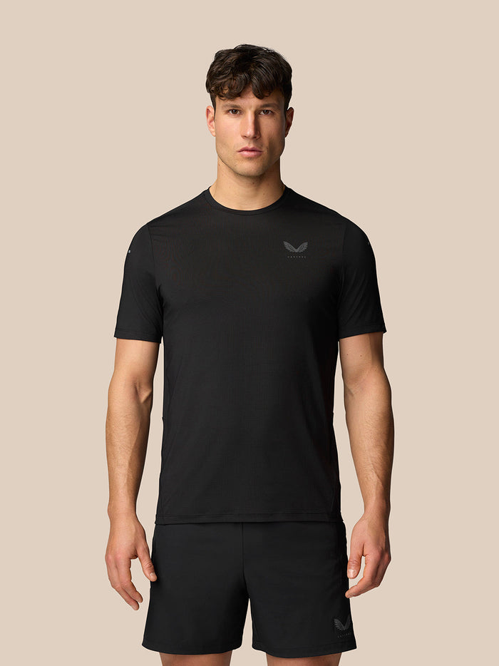 Male model wearing a black Apex Training T-Shirt in a simple studio setting