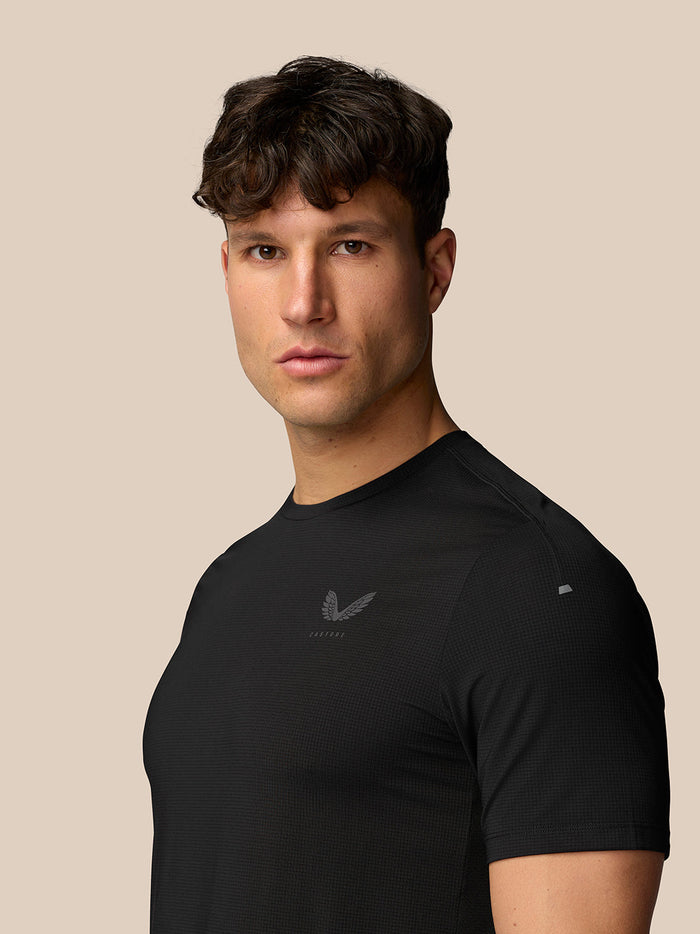 Side profile of a man in black Apex Training T Shirt with a small Castore logo on the chest.