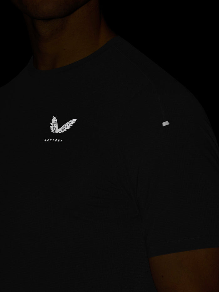 Close-up of black Apex Training T-Shirt chest with Castore crest and reflective sleeve badge.