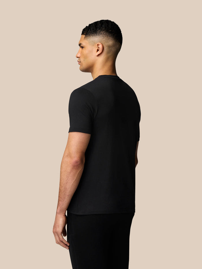 Rear view of a male model wearing a black Graphic Lifestyle T-Shirt.