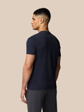 Side profile of male model wearing midnight navy Castore graphic T shirt, front logo visible