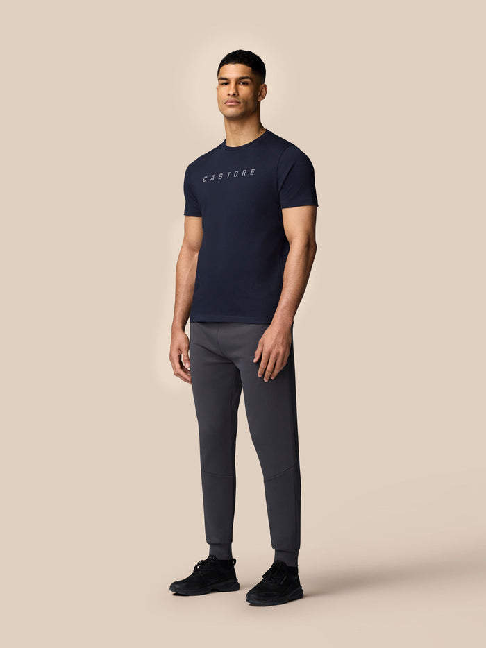Rear view of male model in midnight navy Castore graphic T shirt, showing clean back and short sleeves
