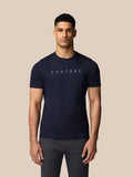 Male model wearing navy graphic Castore T shirt with crew neck and drop shoulders against a beige background