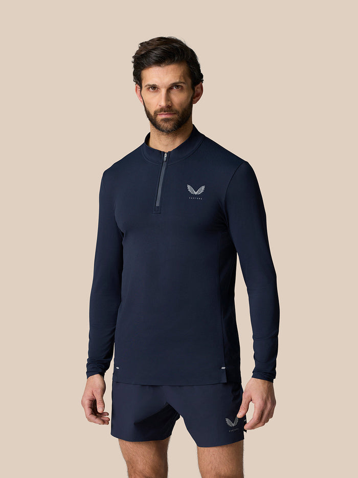 Male model in midnight navy Zone Training 1/4 Zip Top with long sleeves and chest logo