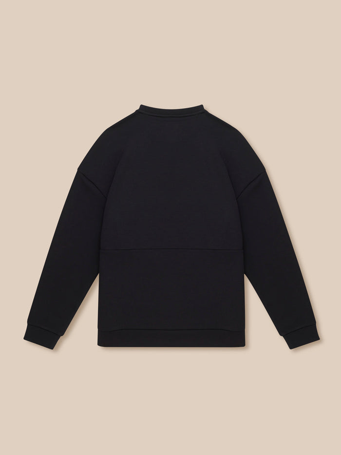Back view of a black crew neck sweatshirt laid flat on a beige background