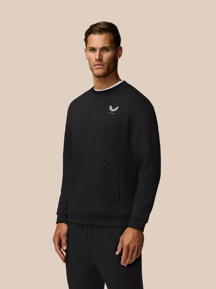 Male model wearing a black Travel Lifestyle Sweatshirt with a small white wing logo on the chest