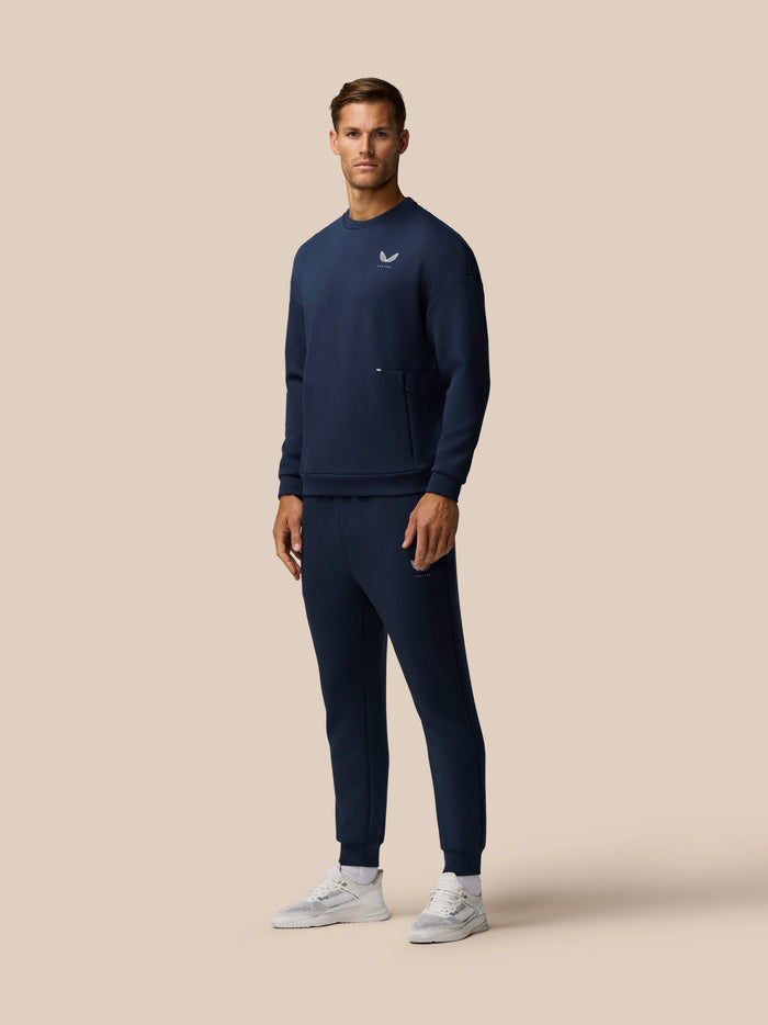 Male model wearing navy Travel Lifestyle Sweatshirt with logo on the chest and a zip pocket