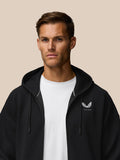 Close up of male model in black Travel Lifestyle Zip Hoodie with hood on and Castore logo on the chest.