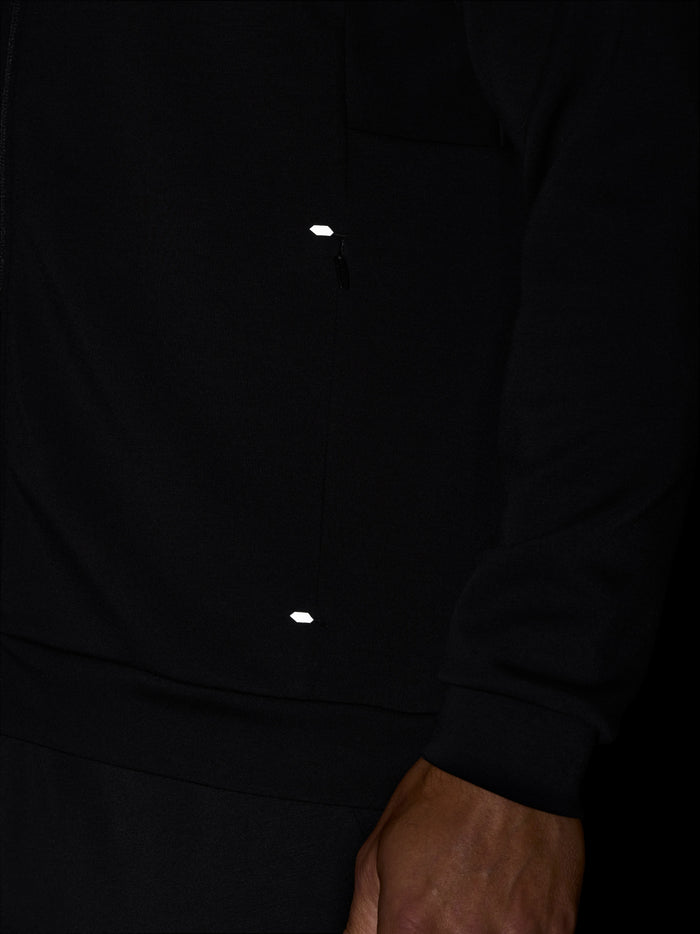 Close-up of black Travel Zip Hoodie chest with zipper and small white Castore emblem.