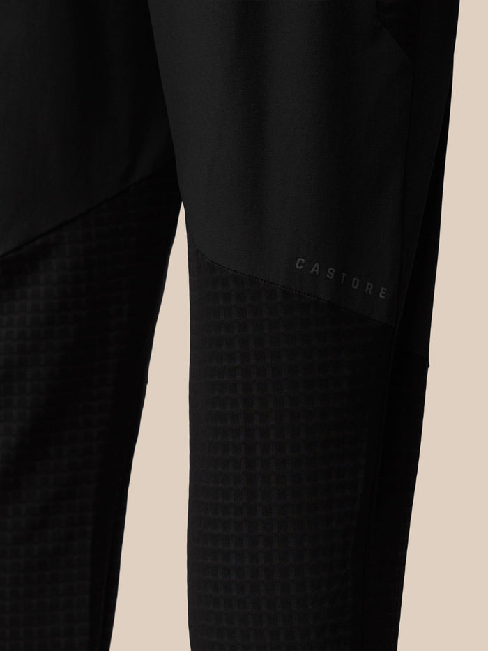 Close-up of black Flex Winterised Woven Joggers showing a textured lower leg panel and Castore logo.