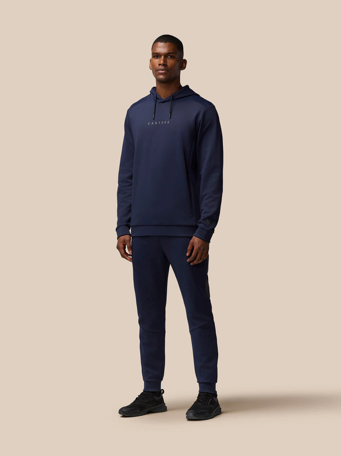 Male model in navy Castore Flex Thermo Pant set with logo on chest and left leg.
