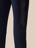 Close-up of navy pant leg showing a black stripe and Castore branding.