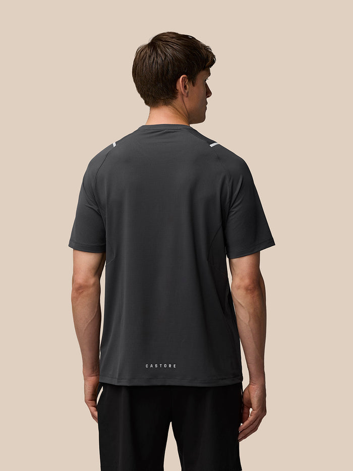 Back view of a man wearing gunmetal Apex Training T Shirt showing reflective shoulder details and Castore branding at the back hem.
