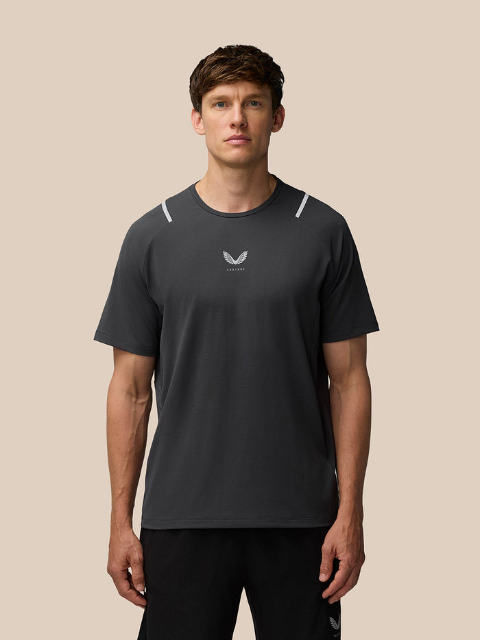 Front view of a man wearing Apex Training T Shirt in gunmetal with reflective shoulder details and a center chest Castore logo.