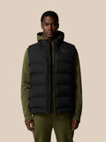 Man wearing a black sleeveless puffer vest over an olive hoodie with a front zipper