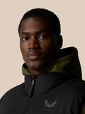 Portrait of a man wearing black water resistant puffer gilet with olive hood lining and front zipper