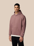 Male model wearing mauve Adapt Lifestyle Hoodie with hood up and chest logo.