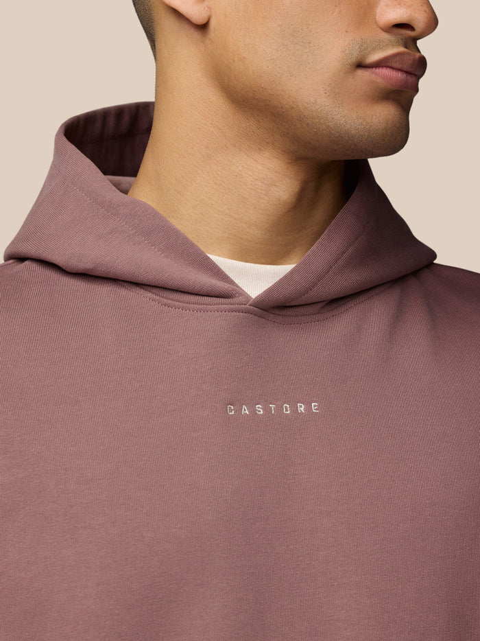Close-up of mauve Adapt Lifestyle Hoodie neckline showing the hood and Castore logo on the chest.