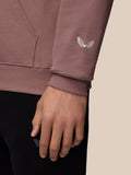 Close-up of mauve hoodie sleeve with white embroidered wing logo and ribbed cuff.