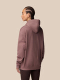 Back view of a model wearing Adapt Lifestyle Hoodie in mauve with braided hair and the hood resting at the back.