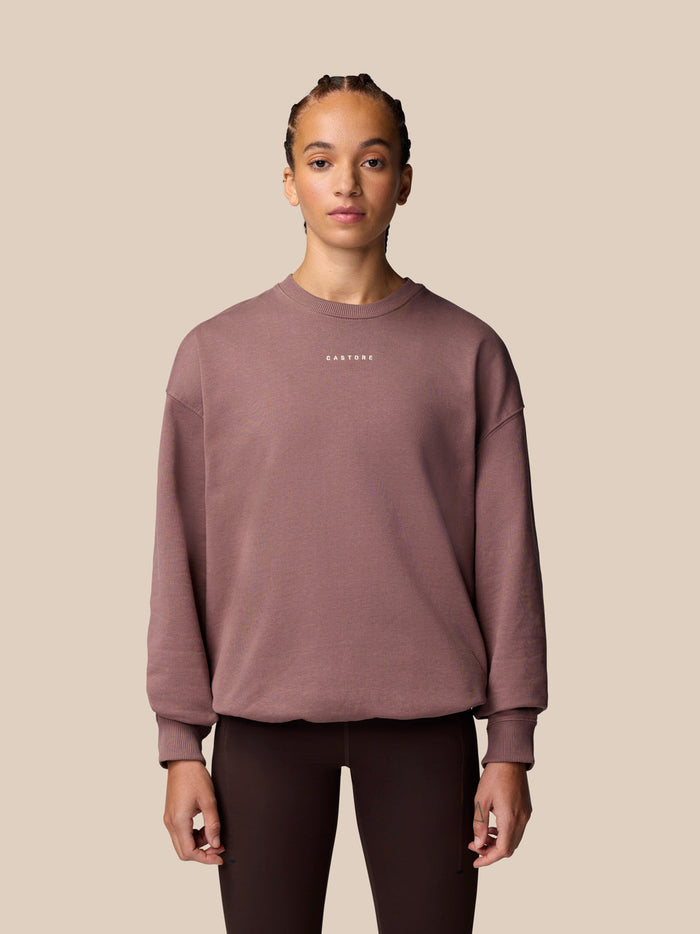 Model wearing mauve Adapt Lifestyle Sweatshirt with oversized silhouette and embroidered Castore logo on chest.