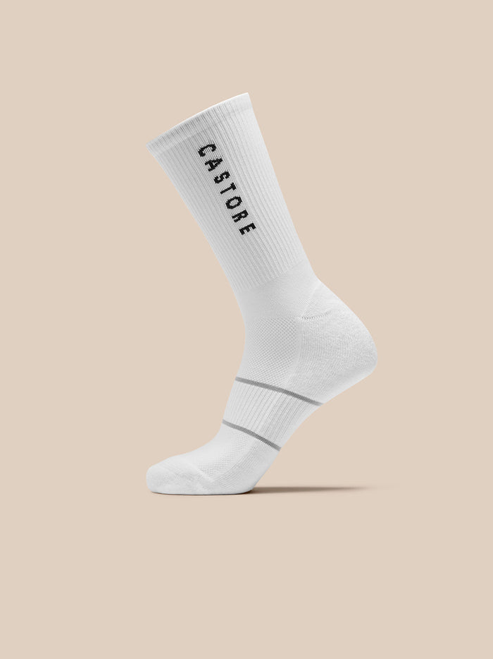 White crew sock with ribbed cuff and two grey stripes near the ankle featuring Castore graphic.