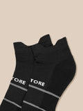 Close-up of black ankle socks with white Castore branding and gray stripes