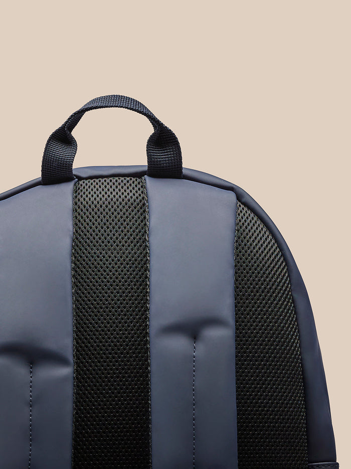 Navy backpack back close up highlighting top handle and padded mesh shoulder strap