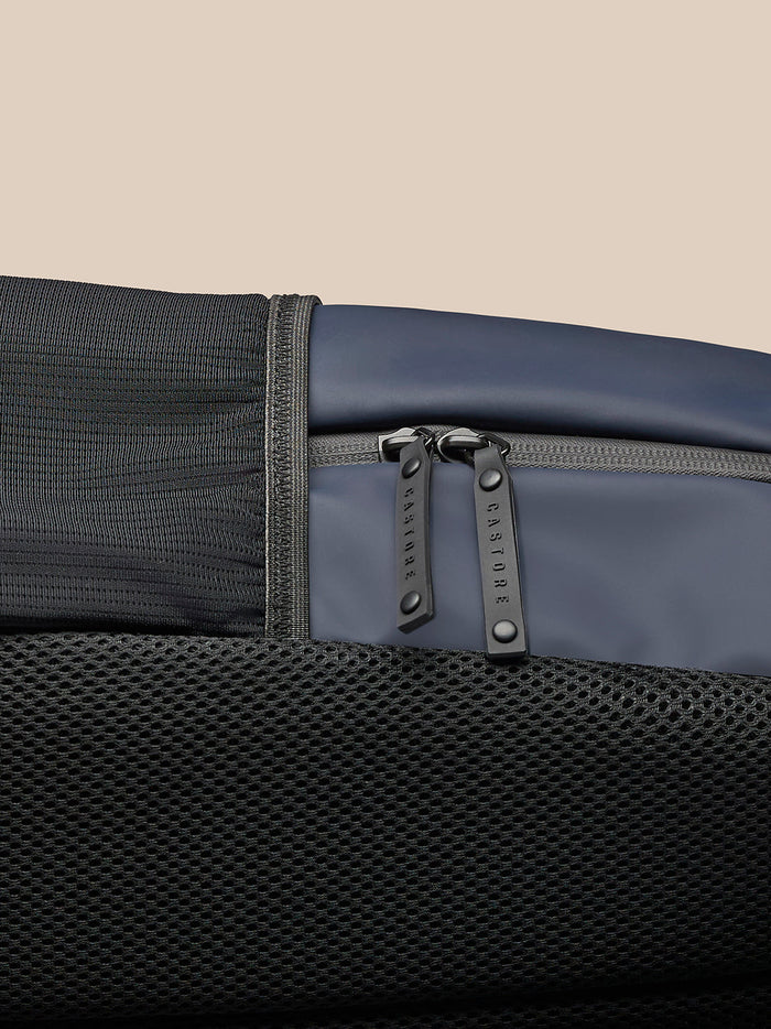 Model wearing navy Active Small Backpack on back in side profile.