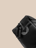 Close-up of the wash bag zipper with a branded pull and visible logo on black fabric.