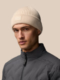Stone colored ribbed knit beanie with Castore logo on the foldover.