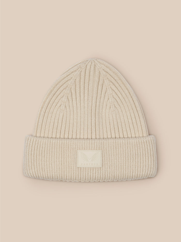 Stone ribbed knit beanie laid flat against a beige background with a front Castore label