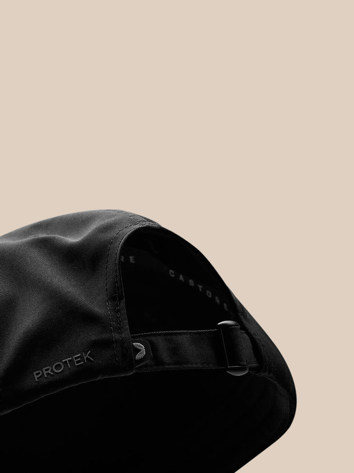 Back view of black cap with adjustable strap and metal buckle