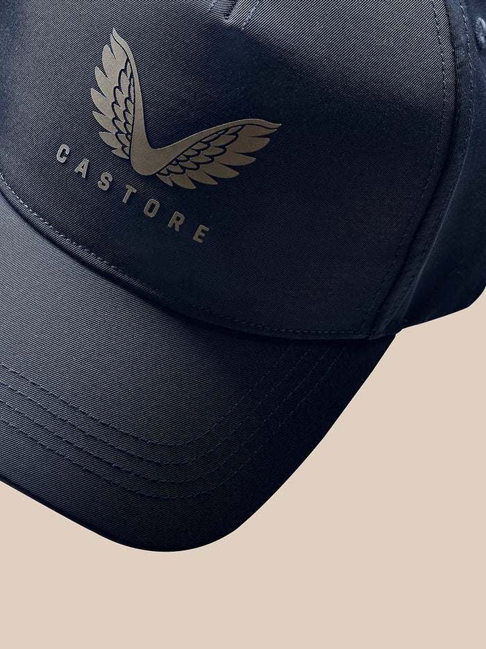 Detail view of navy cap featuring PROTEK branding along the side and a curved visor.