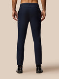 Back view of a man in midnight navy Castore Golf Lightweight Club Trousers with branding on the right thigh and rear waistband