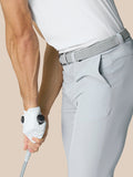 Side view of a golfer in light grey Golf Club Trousers with a woven belt holding a club.
