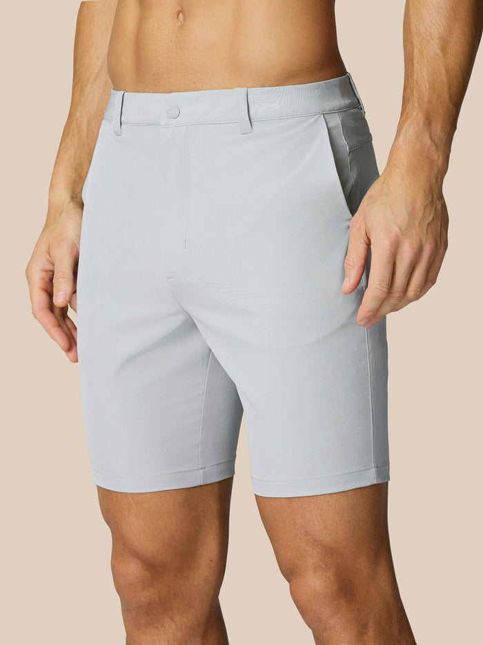 Light gray golf shorts with belt loops and side pockets on a male model.