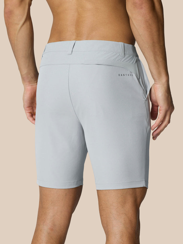 Back view of light grey golf shorts on a model showing waistband with belt loops, back pocket at right rear and branding on the right thigh