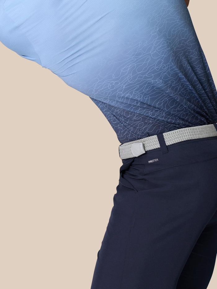 Close up of navy ProTek golf shorts with a light gray belt and branding near the back waistband.