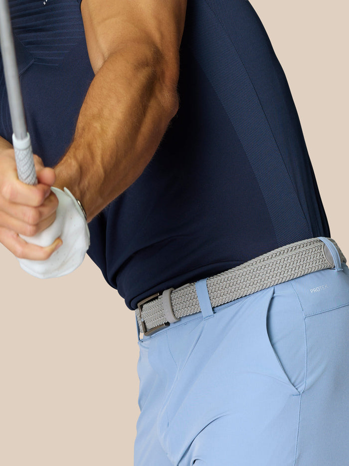 Back view of sky blue golf shorts showing a woven belt and ProTek branding on the back pocket