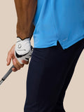 Close-up of the polo hem showing a side slit and AerTek knit fabric on the Cool Blue Golf Club Essential Polo.