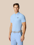 Man wearing a sky blue Golf Club Essential Polo with short sleeves and collar.