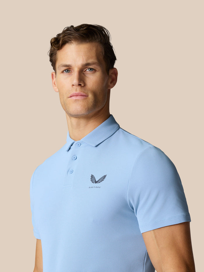 Male model wearing sky blue Golf Club Essential Polo with pointed collar and short sleeves.