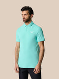 Side profile of a man in a light aqua Golf Club Essential Polo showing the polo collar and chest logo.